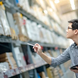 Asian Man in checkered shirt tracking warehouse inventory photo